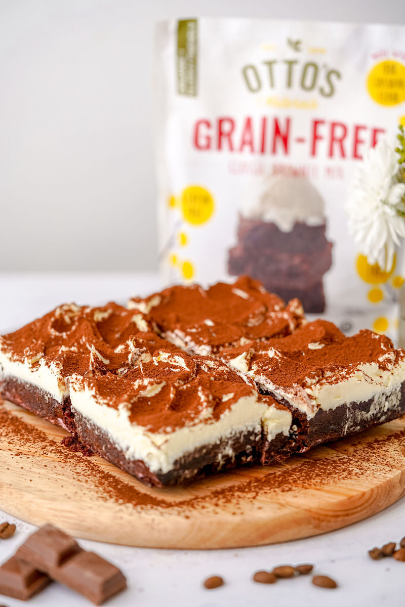 Cassava Flour Brownies with Tiramisu Cream and cocoa powder on top. Otto's Grain-Free Brownie mix in background