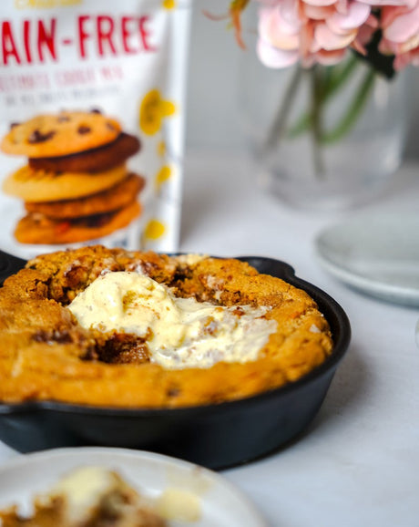 Grain-Free Peanut Butter Cookie skillet with ice cream. Otto's Naturals Grain-Free Ultimate Cookie Mix bag in background