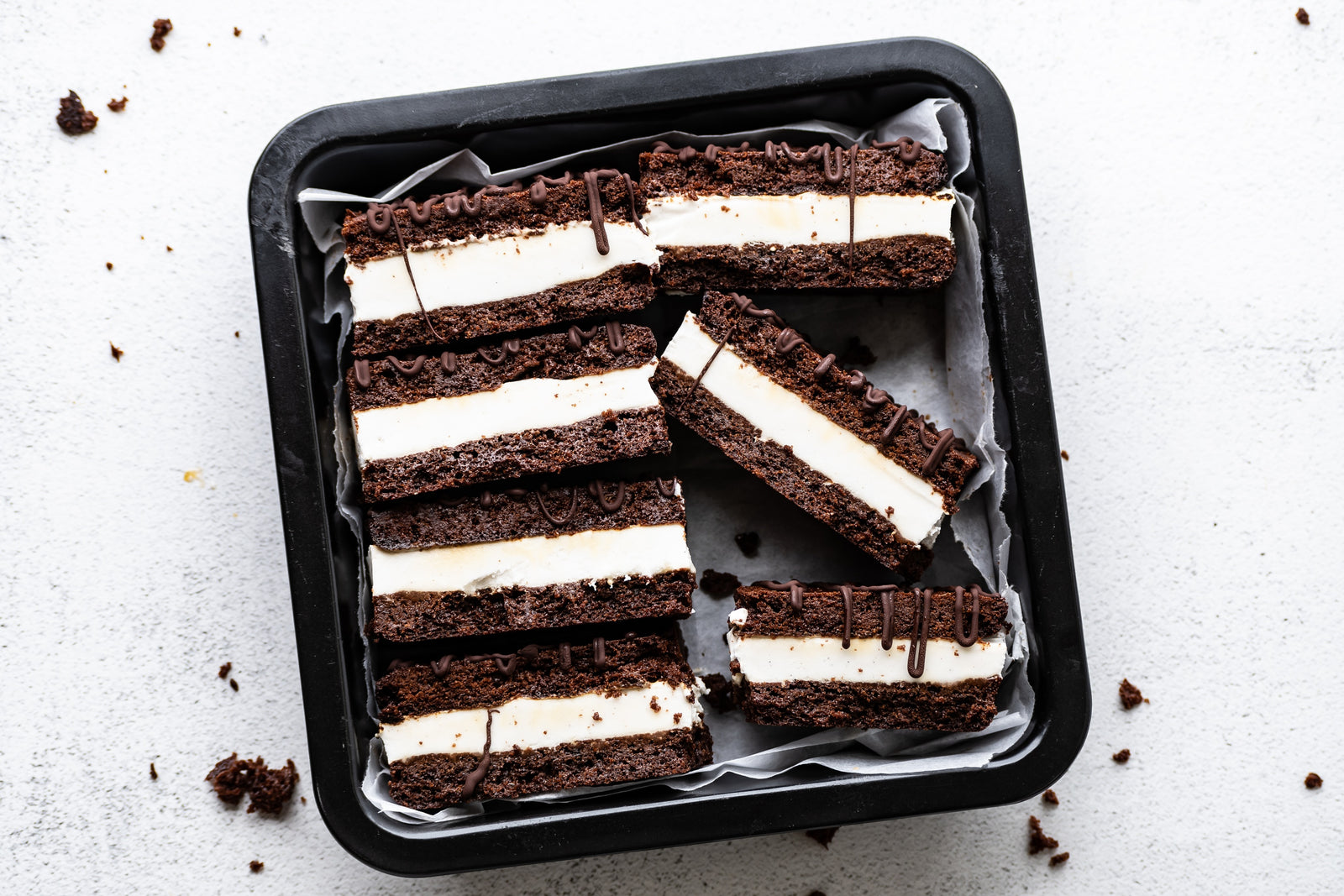 Grain-free brownie ice cream sandwiches lined up in a baking pan.