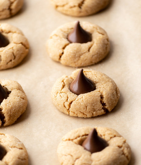 Grain-Free peanut butter blossom cookies on parchment paper